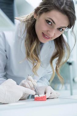 牙科假体义齿假肢工作 假肢手在义齿假牙研究和桌子上工作